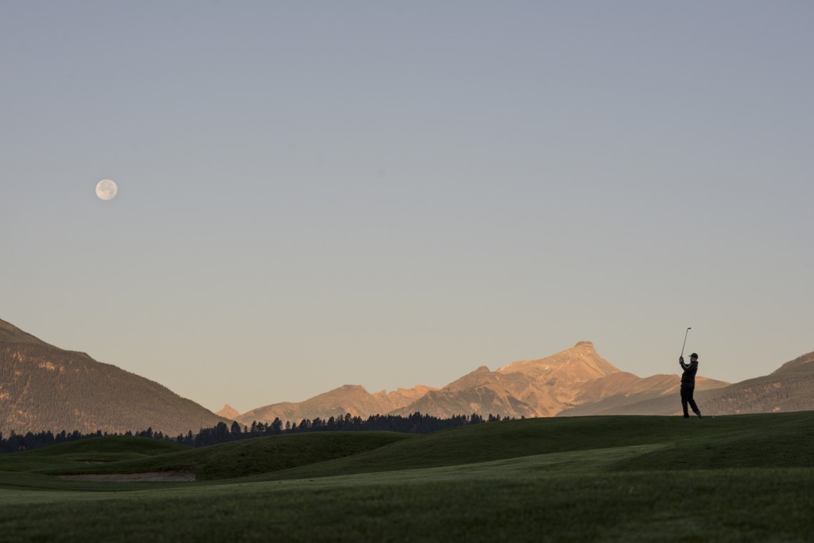 A golfer at Eagle Ranch Golf Resort in Invermere BC. View of Mt. Nelson.